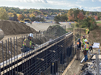 Workers secure rebar to abutment base.